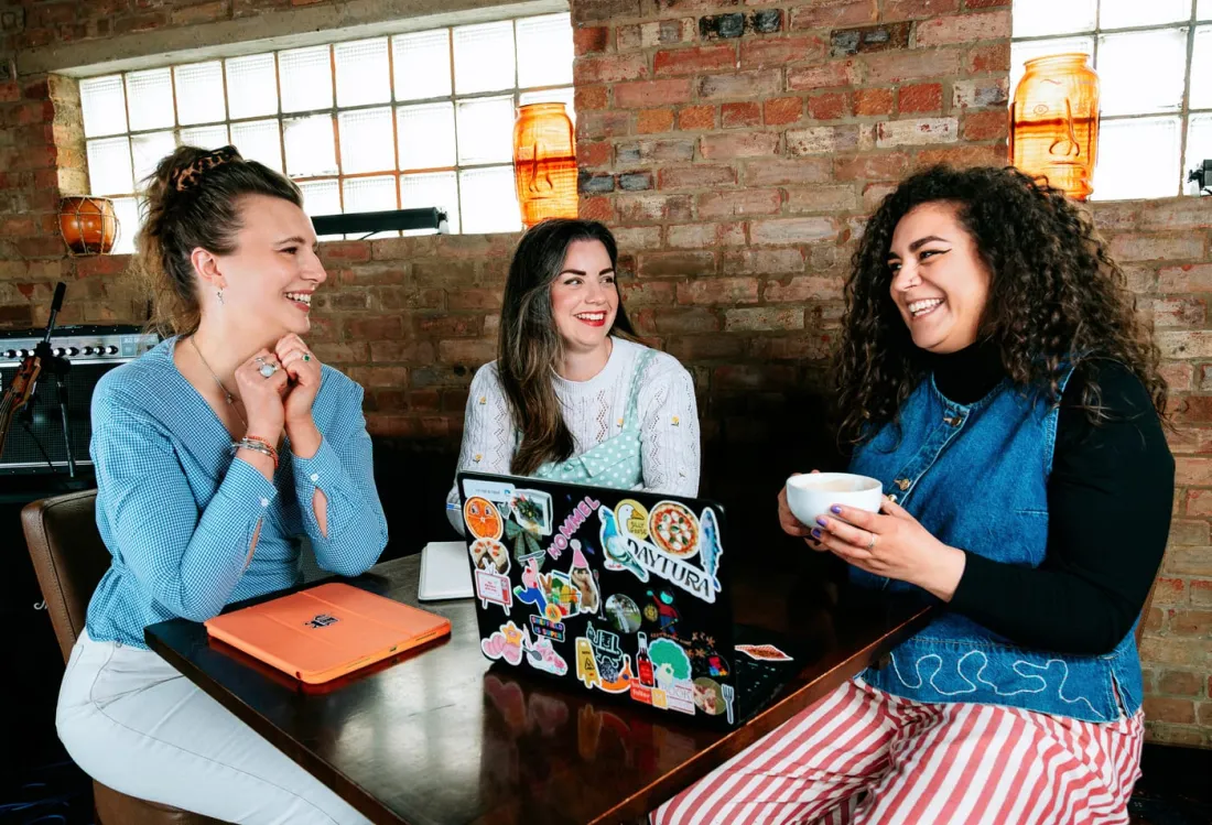 The Checkmate Productions team laughing together around a table